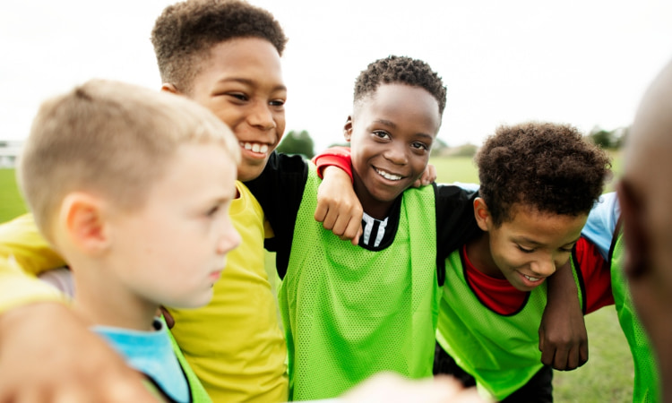 a young sports team gathers for a team huddle